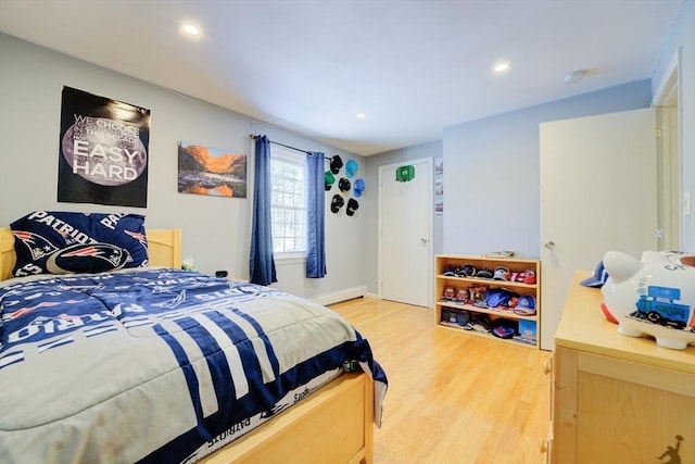 bedroom featuring wood-type flooring and baseboard heating