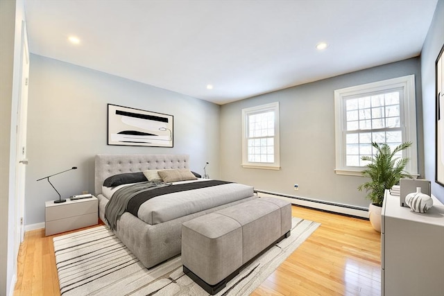 bedroom with a baseboard radiator and light wood-type flooring