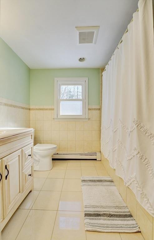 bathroom with tile walls, vanity, tile patterned flooring, and a baseboard radiator