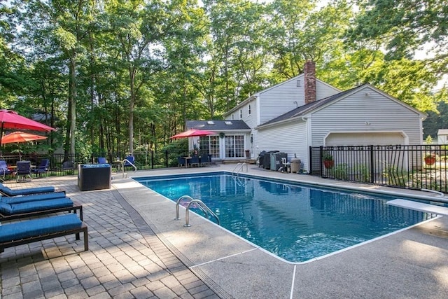 view of pool featuring a patio area and a diving board