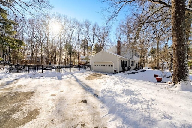 view of snowy exterior with a garage