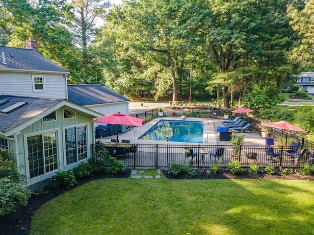 view of pool with a patio and a yard