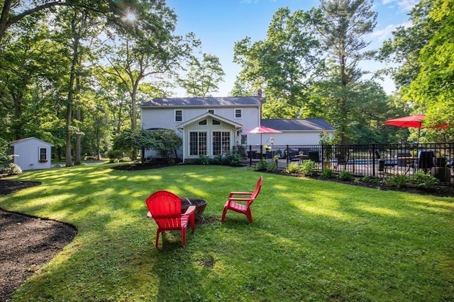 rear view of property featuring a shed and a lawn