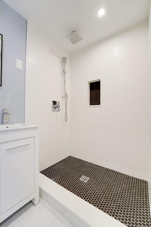 bathroom with vanity and tiled shower