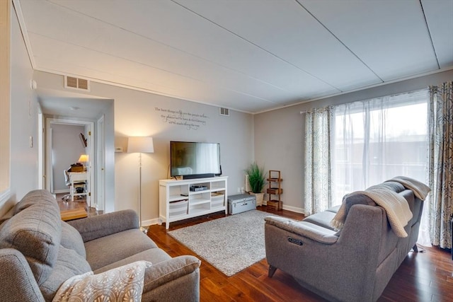 living area featuring visible vents, baseboards, and wood finished floors