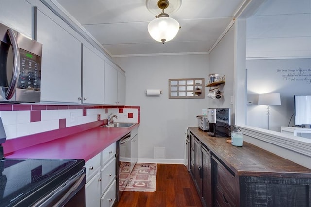 kitchen featuring appliances with stainless steel finishes, ornamental molding, dark wood-style flooring, a sink, and backsplash