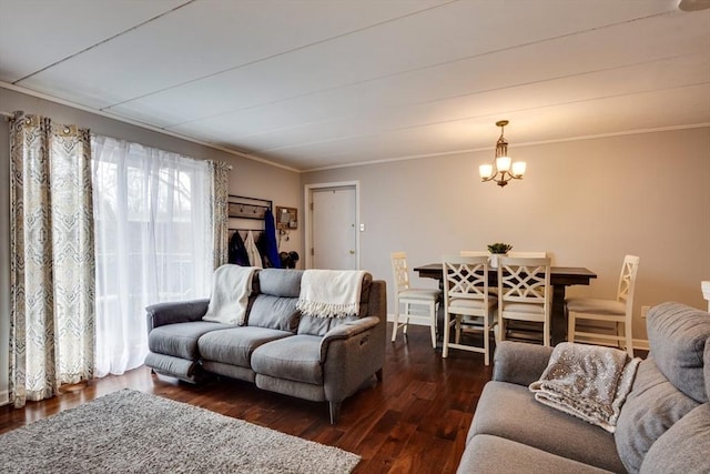 living room with a notable chandelier, ornamental molding, and wood finished floors