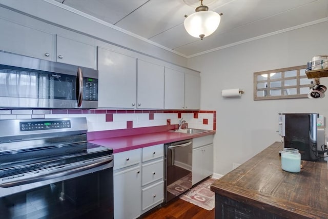 kitchen featuring stainless steel appliances, white cabinets, decorative backsplash, dark wood-style floors, and crown molding