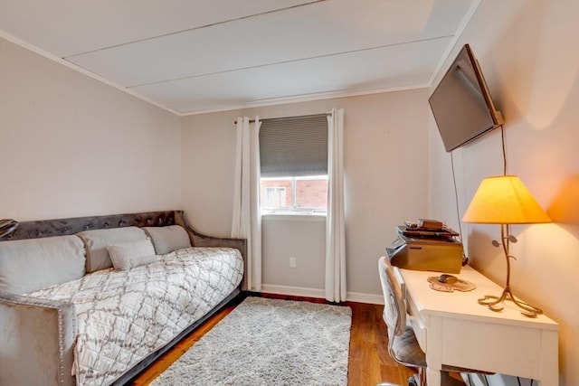 bedroom featuring ornamental molding, baseboards, and wood finished floors