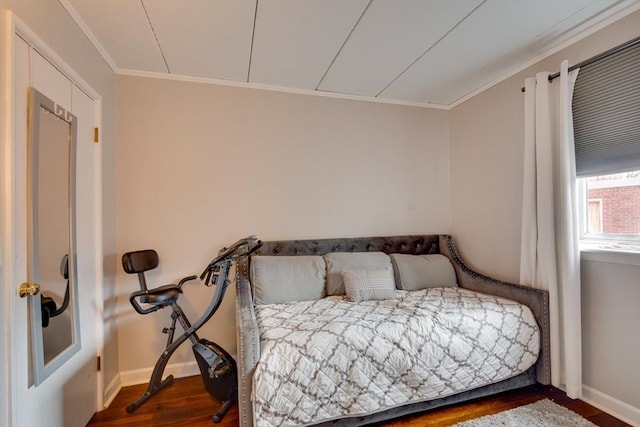 bedroom featuring crown molding, baseboards, and wood finished floors