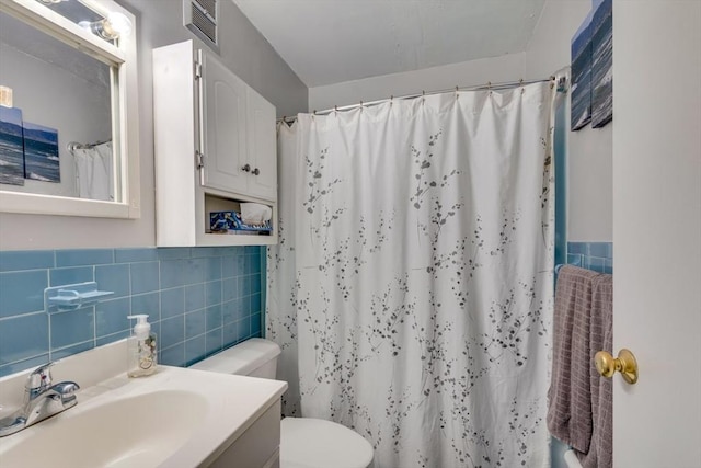 full bathroom with tile walls, curtained shower, visible vents, toilet, and vanity