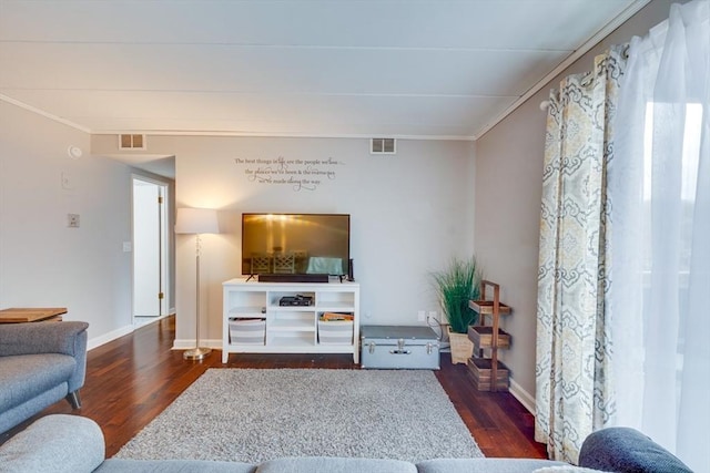 living room featuring crown molding, visible vents, and wood finished floors