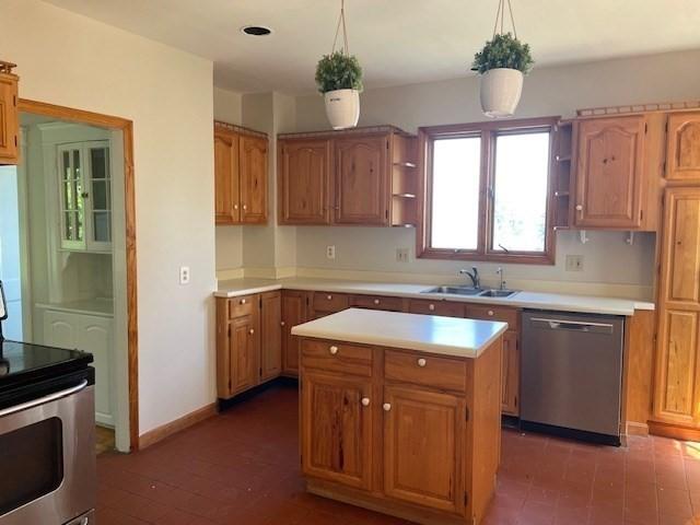 kitchen featuring pendant lighting, sink, stainless steel appliances, and a center island