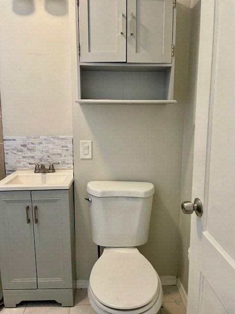 bathroom with vanity, toilet, and decorative backsplash