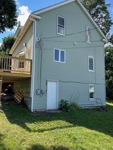 rear view of house with a yard and a deck