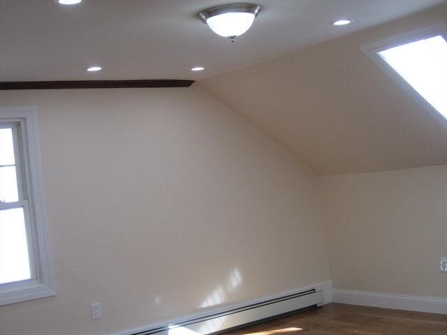 bonus room with dark hardwood / wood-style flooring and vaulted ceiling with skylight