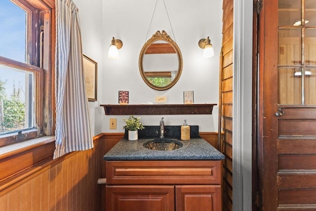 10 Quissett, Falmouth, MA 02543 - bathroom featuring vanity, a wainscoted wall, and wooden walls