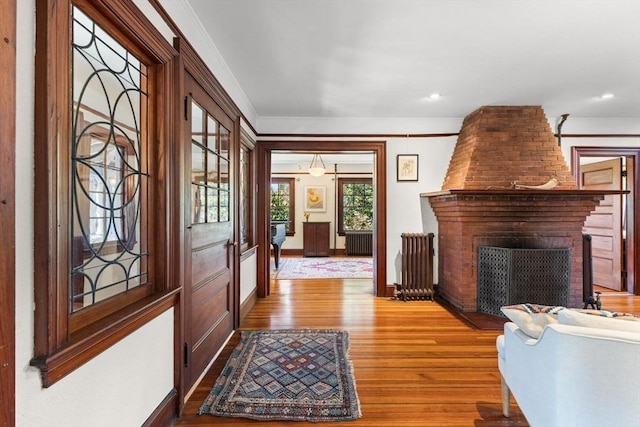 10 Quissett, Falmouth, MA 02543 - foyer with wood finished floors, a fireplace, crown molding, radiator, and baseboards