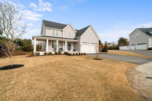 view of front of home with a porch, a garage, and a front lawn