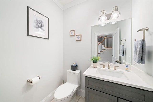 bathroom featuring ornamental molding, vanity, and toilet