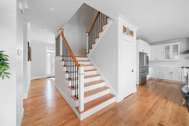 staircase featuring hardwood / wood-style flooring and ornamental molding