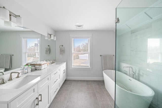 bathroom featuring radiator heating unit, vanity, a healthy amount of sunlight, and a bath