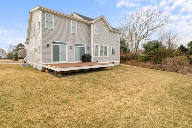 back of house with a wooden deck and a lawn