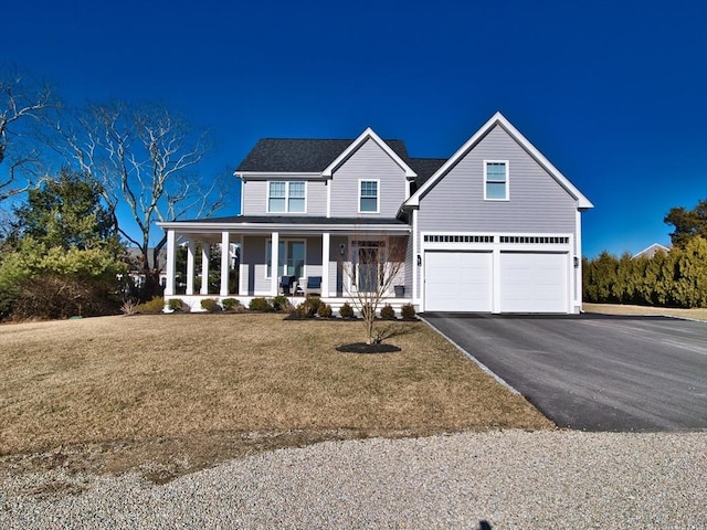 view of front of property featuring a porch, a garage, and a front yard