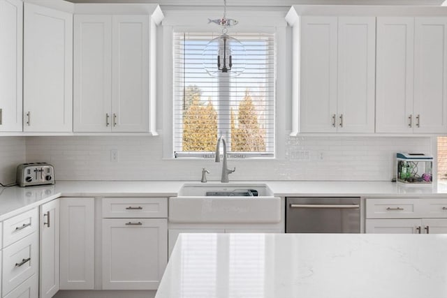 kitchen featuring sink, hanging light fixtures, dishwasher, decorative backsplash, and white cabinets