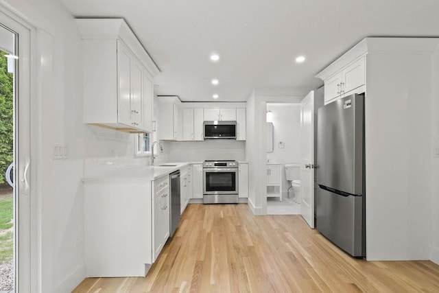 176 Palmer Ave Unit 2, Falmouth, MA 02540 - kitchen with stainless steel appliances, light wood-style floors, light countertops, recessed lighting, and white cabinets