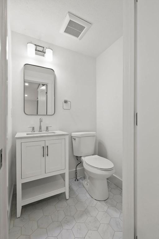 176 Palmer Ave Unit 2, Falmouth, MA 02540 - half bath featuring toilet, vanity, tile patterned flooring, and baseboards