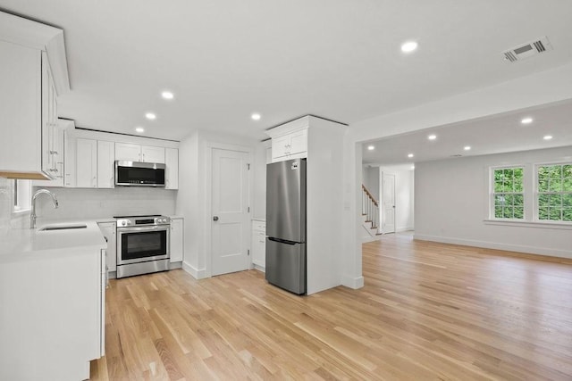 176 Palmer Ave Unit 2, Falmouth, MA 02540 - kitchen featuring stainless steel appliances, a sink, recessed lighting, light wood-type flooring, and light countertops