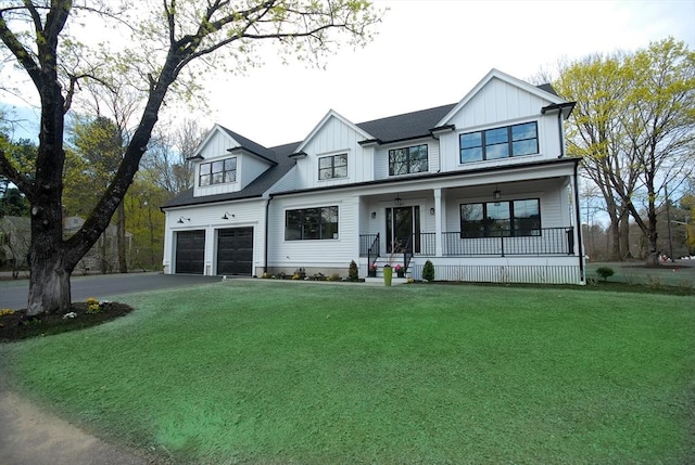 modern farmhouse style home with a front yard, a garage, covered porch, board and batten siding, and aphalt driveway