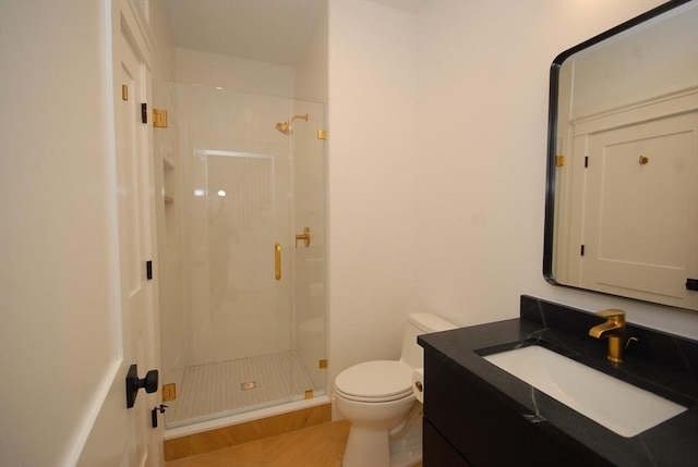 bathroom featuring toilet, a stall shower, and vanity