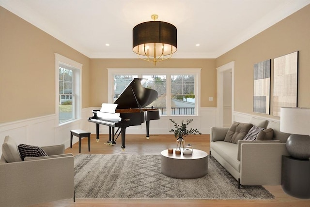 sitting room featuring wainscoting, wood finished floors, recessed lighting, and a decorative wall