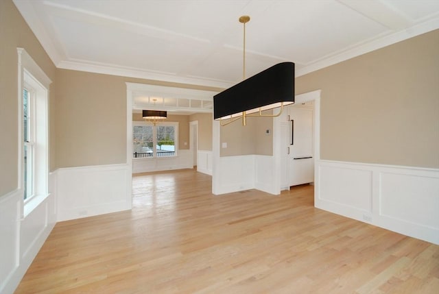 unfurnished dining area featuring a wainscoted wall and light wood finished floors