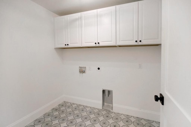 clothes washing area featuring electric dryer hookup, baseboards, cabinet space, and washer hookup