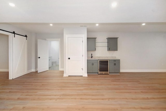 bar featuring recessed lighting, baseboards, a barn door, and beverage cooler