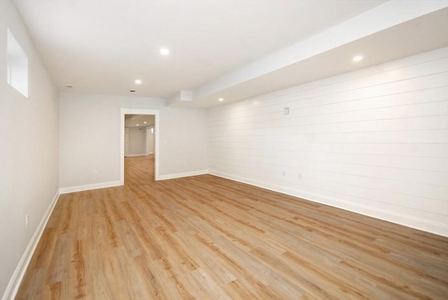 empty room featuring light wood finished floors, recessed lighting, and baseboards