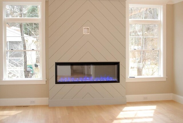 interior details with visible vents, baseboards, and a glass covered fireplace