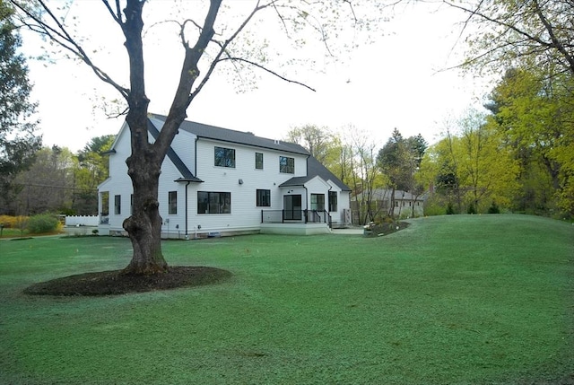 rear view of house featuring a lawn