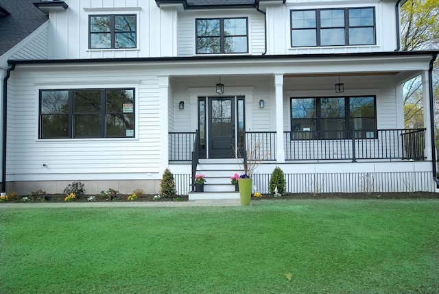 view of front of property with a porch, board and batten siding, and a front lawn