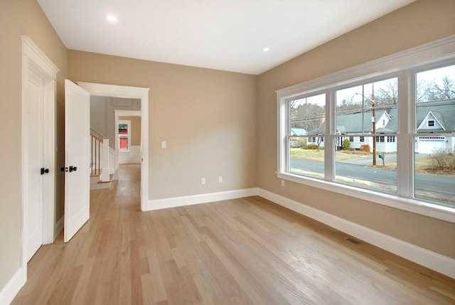 empty room featuring light wood-style flooring, recessed lighting, a wealth of natural light, and baseboards