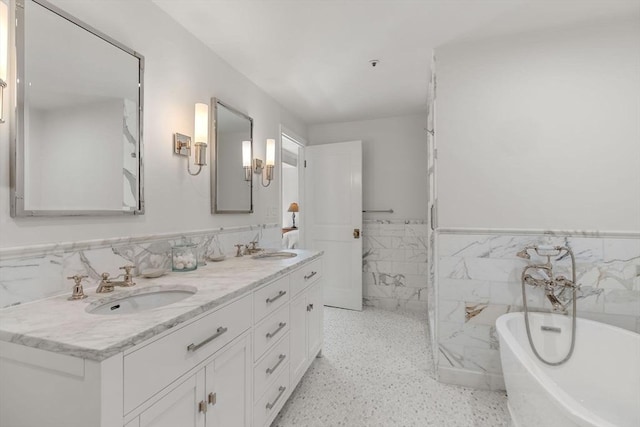 300 Boylston St Unit 907, Boston, MA 02116 - bathroom featuring double vanity, a freestanding tub, wainscoting, tile walls, and a sink