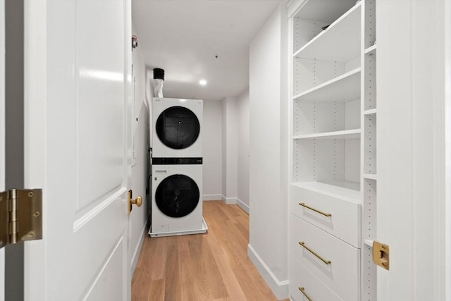 300 Boylston St Unit 907, Boston, MA 02116 - laundry room with baseboards, stacked washer and clothes dryer, and light wood-style flooring