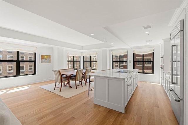 300 Boylston St Unit 907, Boston, MA 02116 - kitchen with a kitchen island, stainless steel built in fridge, light stone countertops, black electric cooktop, and light wood finished floors