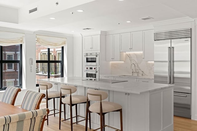 300 Boylston St Unit 907, Boston, MA 02116 - kitchen featuring a sink, stainless steel appliances, white cabinetry, a kitchen island, and visible vents