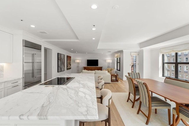 300 Boylston St Unit 907, Boston, MA 02116 - kitchen with a kitchen island, white cabinetry, black electric stovetop, and stainless steel built in refrigerator