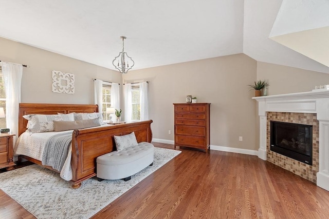 57 Houghton Farm Ln, Bolton, MA 01740 - bedroom with wood finished floors, a tiled fireplace, baseboards, a chandelier, and vaulted ceiling