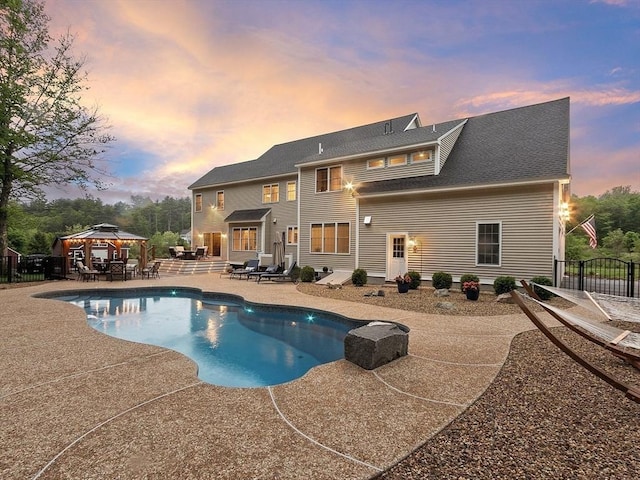 57 Houghton Farm Ln, Bolton, MA 01740 - back of house at dusk featuring a gazebo and a patio area